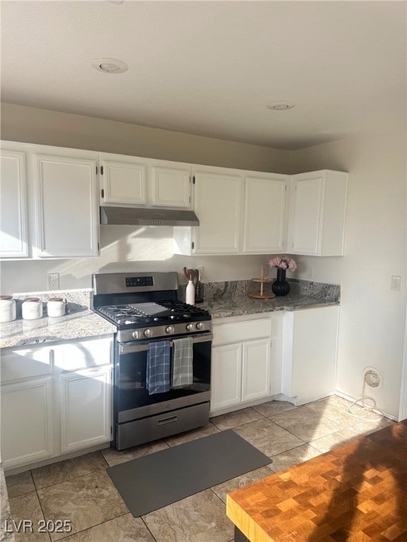 kitchen featuring white cabinetry, gas range, and light stone countertops