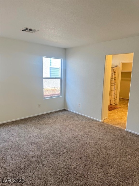 carpeted empty room with a textured ceiling