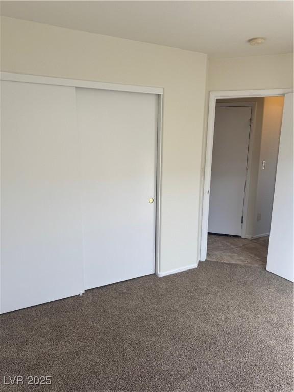 unfurnished bedroom with carpet floors and a closet