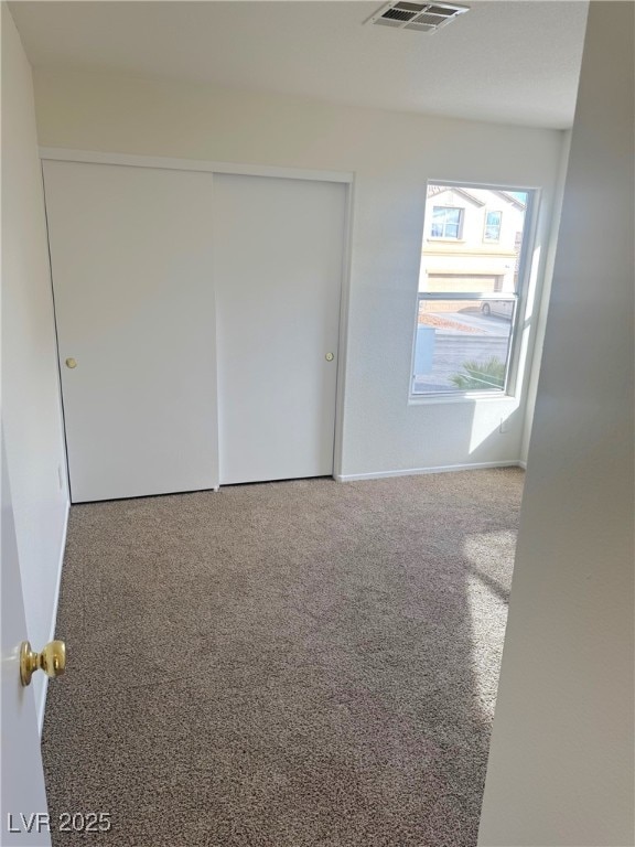 unfurnished bedroom featuring carpet floors and a closet