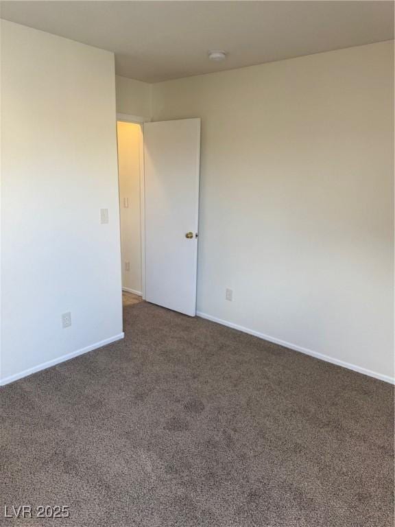 unfurnished room with dark carpet