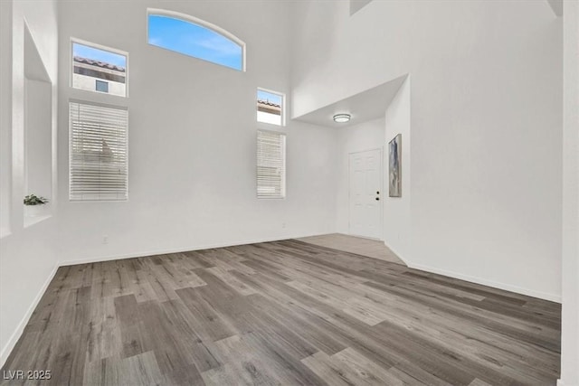 empty room featuring hardwood / wood-style floors and a high ceiling