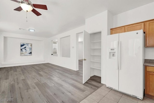 kitchen featuring ceiling fan, white refrigerator with ice dispenser, and light hardwood / wood-style floors