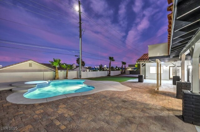 view of swimming pool featuring a pool with connected hot tub, a fenced backyard, and a patio