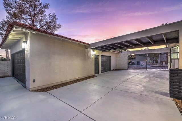 exterior space featuring an attached garage and a gate