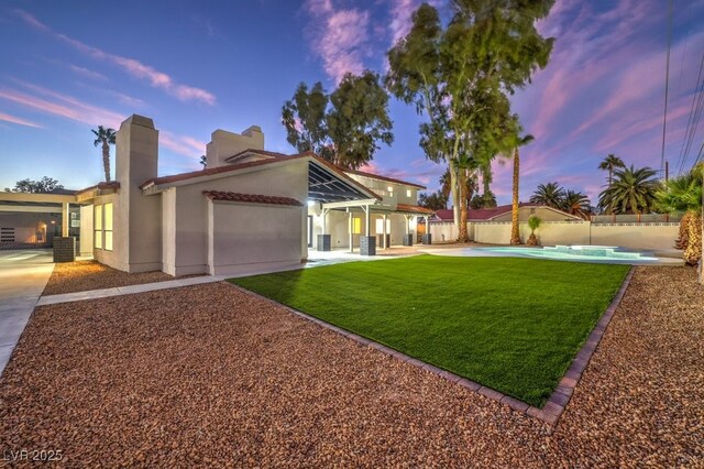 view of front of home featuring a patio, fence private yard, a lawn, a fenced in pool, and stucco siding