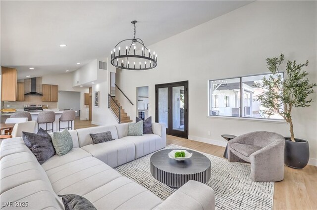 living room featuring recessed lighting, visible vents, stairway, light wood-style floors, and baseboards