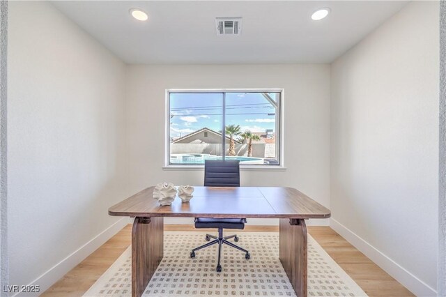 office space featuring light wood finished floors, baseboards, visible vents, and recessed lighting