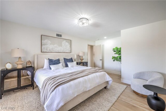 bedroom featuring wood finished floors, visible vents, and baseboards