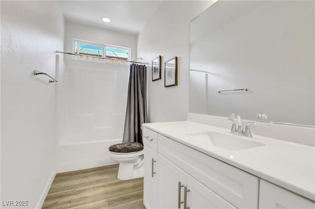 full bathroom featuring hardwood / wood-style flooring, shower / tub combo with curtain, vanity, and toilet