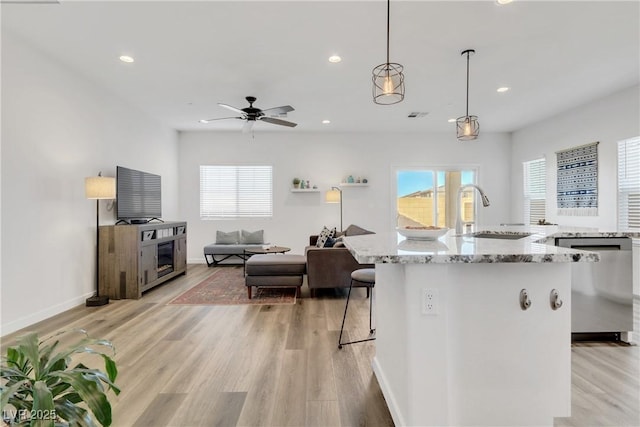 kitchen featuring stainless steel dishwasher, a center island, sink, and pendant lighting