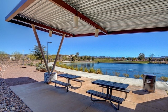 surrounding community with a patio area and a water view