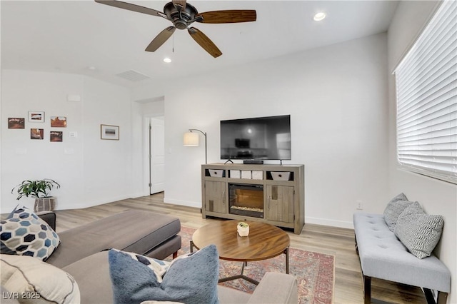 living room with ceiling fan and light hardwood / wood-style flooring