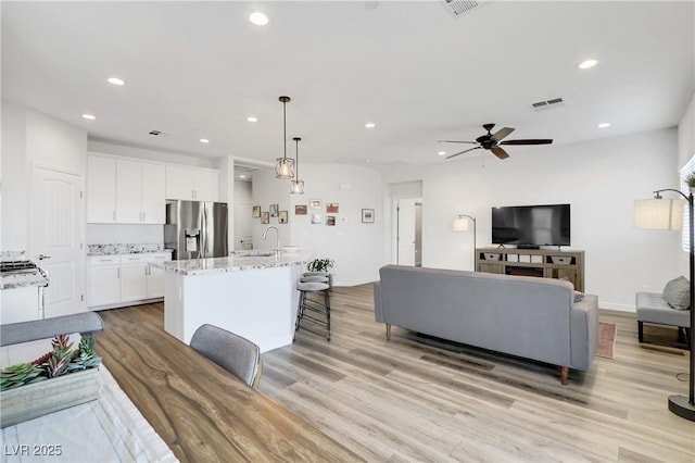 interior space with ceiling fan, sink, and light hardwood / wood-style flooring