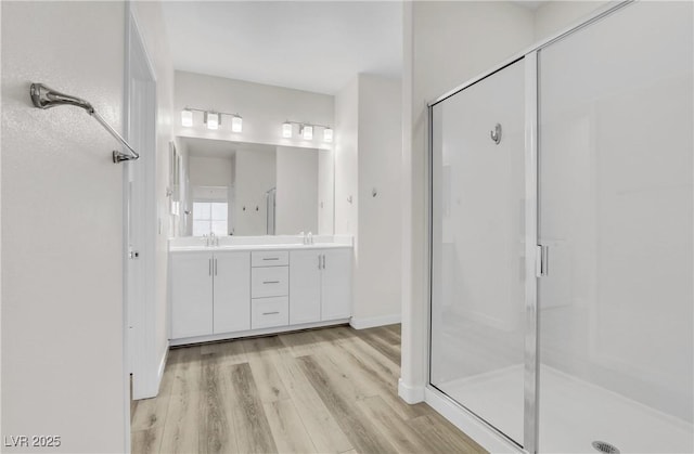 bathroom with vanity, a shower with door, and hardwood / wood-style floors