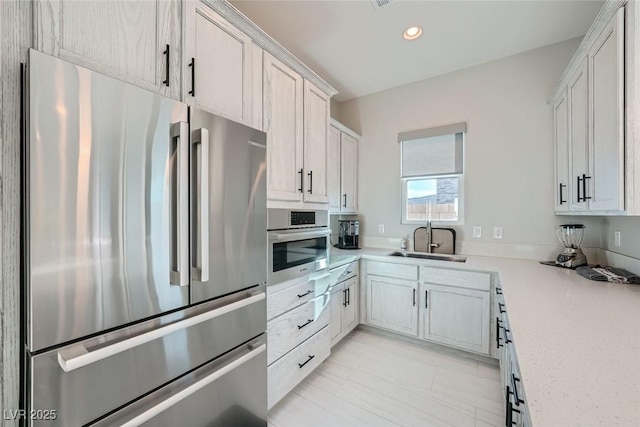 kitchen featuring stainless steel appliances, sink, and white cabinets