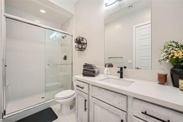 bathroom featuring vanity, an enclosed shower, and toilet