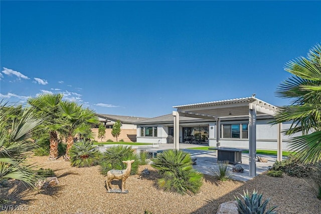 back of property with a pergola and a patio