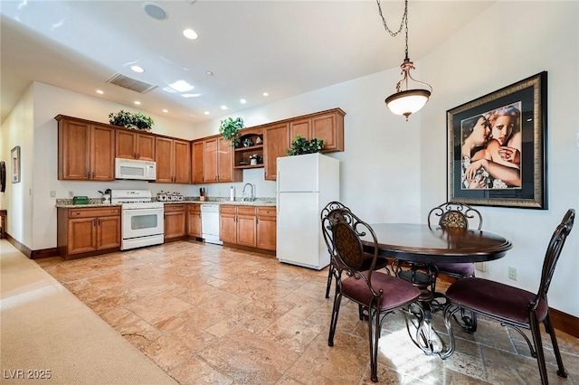 kitchen featuring sink, white appliances, and decorative light fixtures