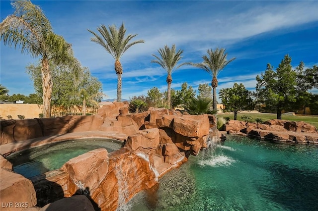 view of swimming pool with an in ground hot tub and pool water feature