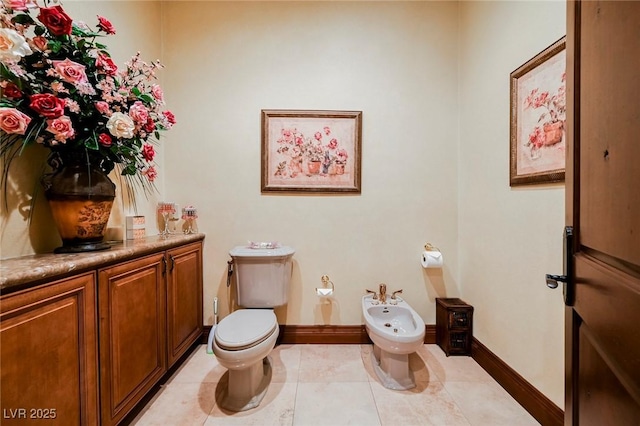 bathroom with a bidet, tile patterned floors, and toilet