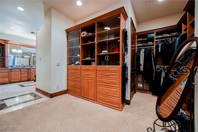 walk in closet featuring light carpet