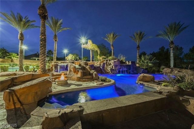 pool at twilight with an outdoor fire pit