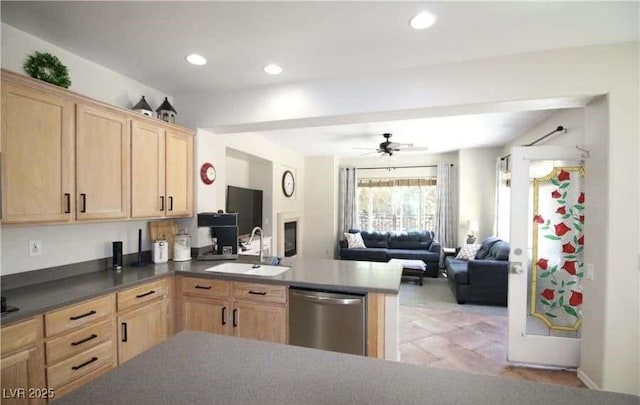 kitchen with stainless steel dishwasher, kitchen peninsula, sink, and light brown cabinets