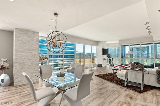 dining space with wood finished floors and an inviting chandelier