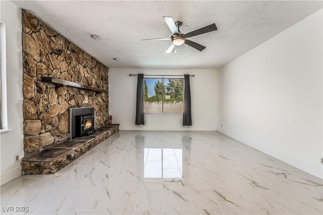 unfurnished living room with ceiling fan, a textured ceiling, and a wood stove