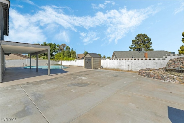 view of patio / terrace with a fenced in pool and a shed