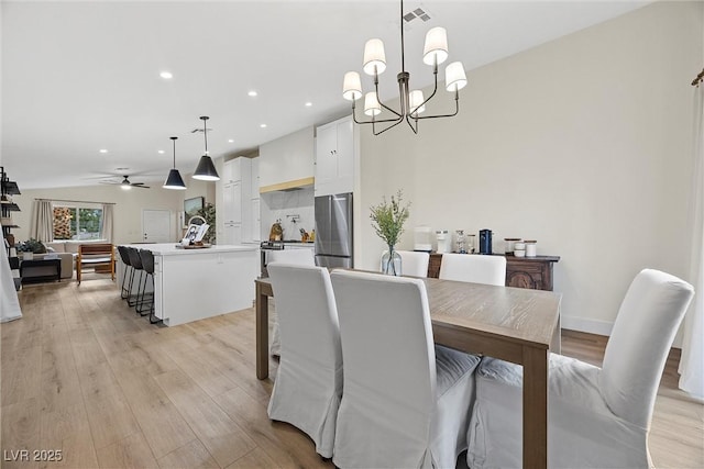 dining room featuring ceiling fan with notable chandelier and light wood-type flooring