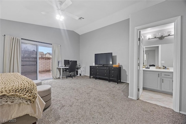 bedroom featuring ceiling fan, ensuite bathroom, access to outside, vaulted ceiling, and light colored carpet