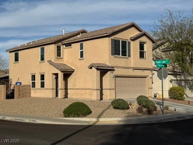 view of front facade featuring a garage, concrete driveway, fence, and stucco siding