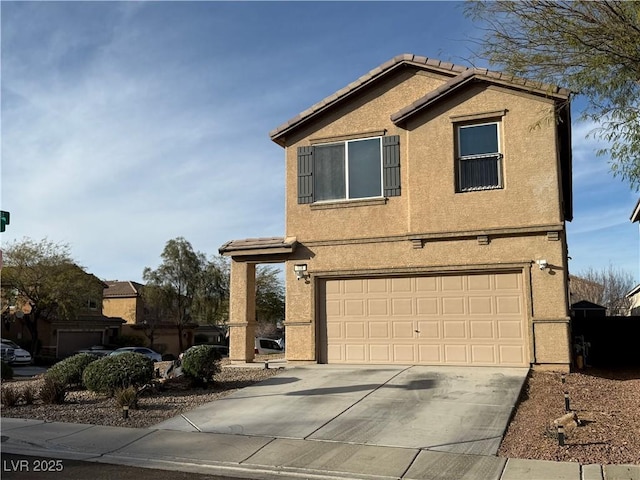 traditional-style house featuring a garage, driveway, a tiled roof, and stucco siding