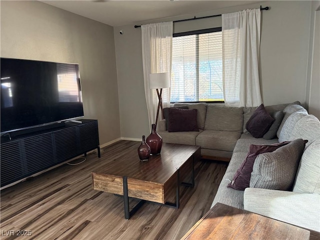 living area featuring baseboards and wood finished floors