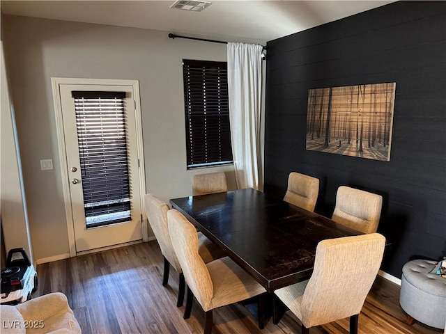 dining space with visible vents, baseboards, and wood finished floors