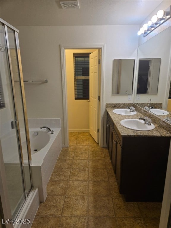 bathroom with a stall shower, a garden tub, and a sink