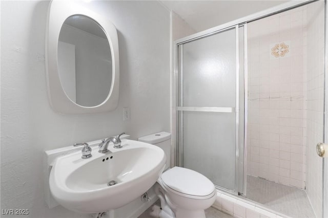 bathroom with sink, an enclosed shower, and toilet