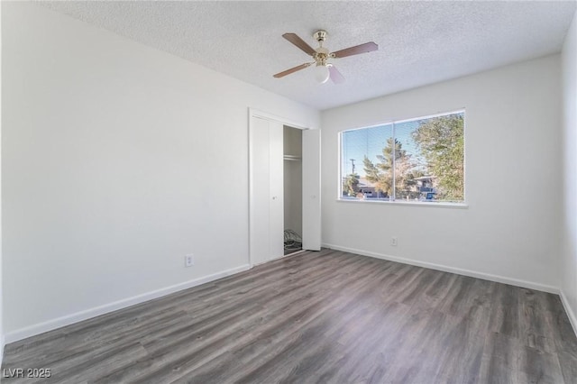 unfurnished bedroom with dark hardwood / wood-style flooring, ceiling fan, a closet, and a textured ceiling