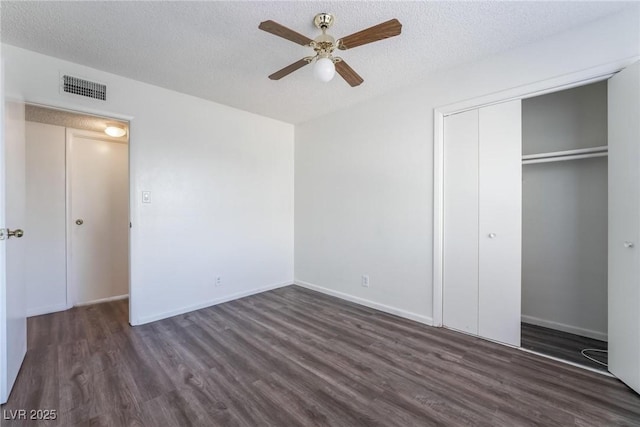 unfurnished bedroom featuring ceiling fan, dark wood-type flooring, a closet, and a textured ceiling