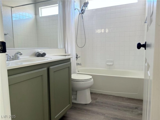 full bathroom with vanity, wood-type flooring, toilet, and tiled shower / bath