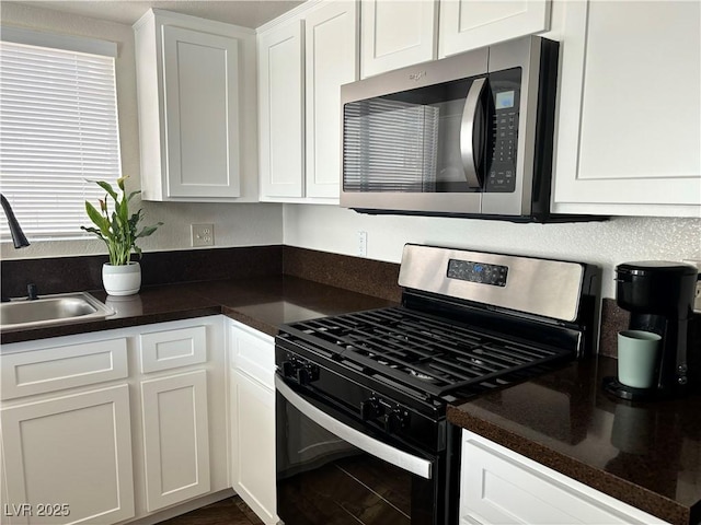 kitchen featuring stainless steel appliances, sink, and white cabinets