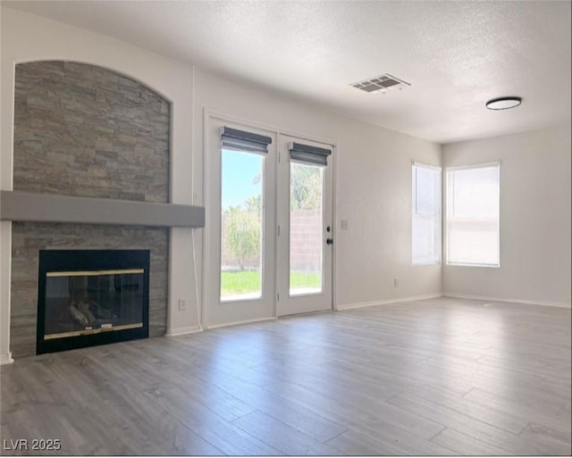 unfurnished living room with hardwood / wood-style flooring and a textured ceiling