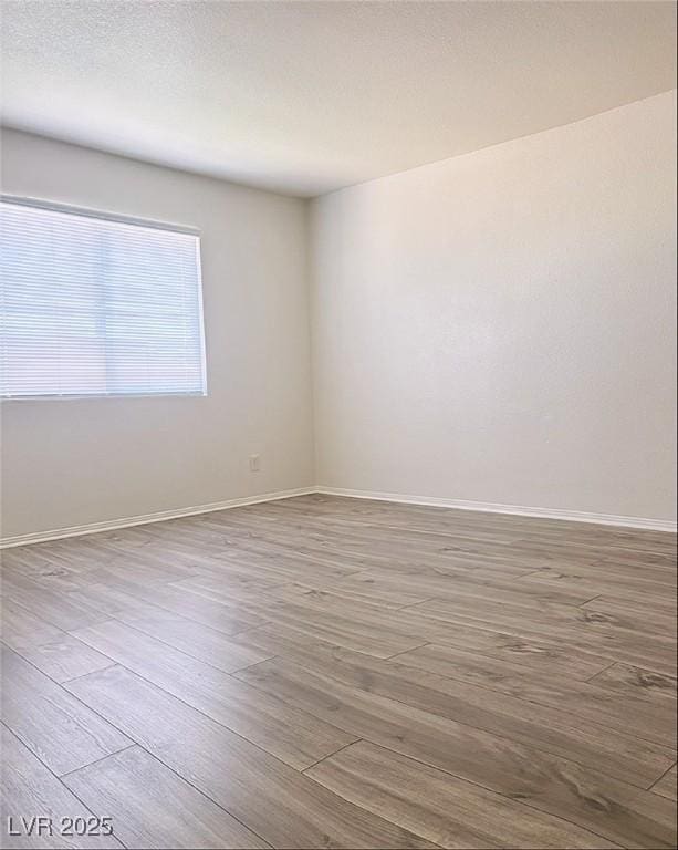 empty room with hardwood / wood-style flooring and a textured ceiling