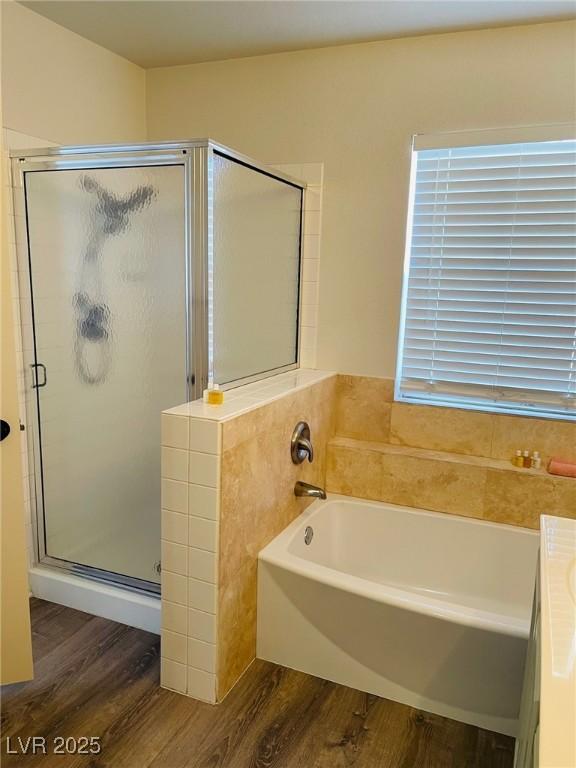 bathroom featuring vanity, hardwood / wood-style floors, and plus walk in shower