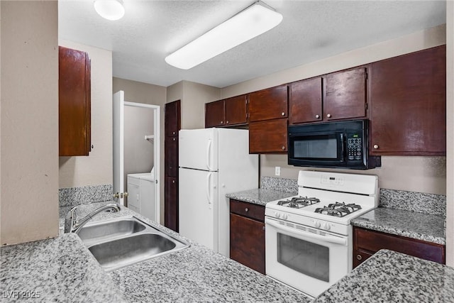 kitchen featuring sink, white appliances, washer and clothes dryer, and a textured ceiling