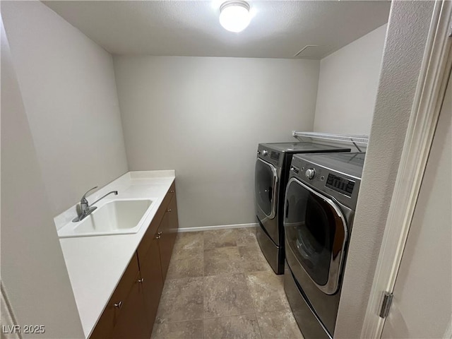 laundry area with cabinet space, a sink, washer and clothes dryer, and baseboards