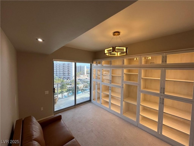 interior space with carpet floors, a view of city, baseboards, and recessed lighting