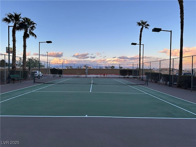 view of tennis court featuring community basketball court and fence